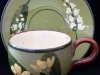 Watcombe Pottery, Cup and Saucer with Lily of the valley and primrose design